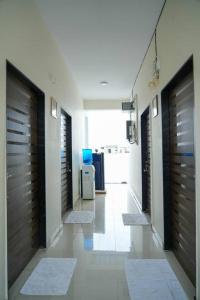 a hallway with wooden doors and a room with rugs at A/C room with Queen Bed Gachibowli in Hyderabad