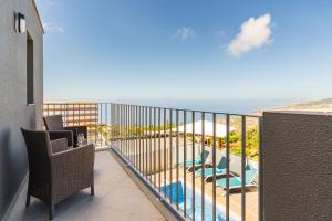 ein Balkon mit Stühlen und Blick auf das Meer in der Unterkunft Bella Vista (Heated Pool & Private Parking) in Arco da Calheta
