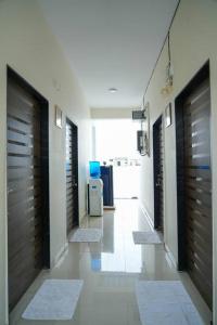 um corredor com portas de madeira e uma sala com tapetes em AC Queen Room Near Wipro Circle Gachibowli em Hyderabad