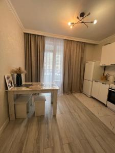 sala de estar con mesa y cocina en Nurly Zhol apartment, en Promyshlennyy