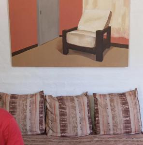 sala de estar con silla y algunas almohadas en Departamento con jardín Centro Luján de Cuyo en Luján de Cuyo