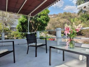 d'une terrasse avec 2 chaises et une table ornée d'un vase de fleurs. dans l'établissement Villa San Rafael, à Tepetzingo