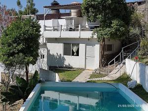 une maison avec une piscine en face d'une maison dans l'établissement Villa San Rafael, à Tepetzingo