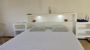 Una cama blanca con dos almohadas encima. en Villa San Rafael, en Tepetzingo