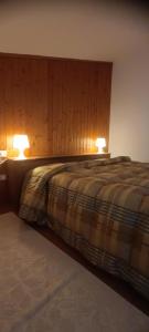 a bedroom with a bed with two lights on it at La Mansarda in Figline Valdarno