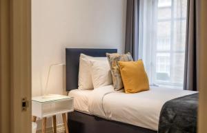 una camera da letto con letto, cuscini e finestra di Luxury 2 bedroom house near Mayfair - Entire Home a Londra