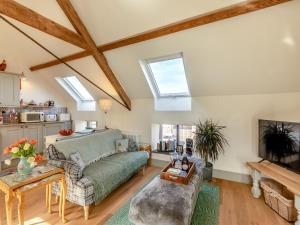 a living room with a green couch and skylights at The Granary - Uk43356 in Branxton