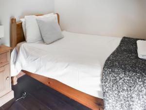 a bedroom with a bed with white sheets and pillows at Uk46715 - The Coach House in Plumstead