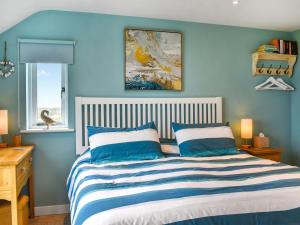 a blue bedroom with a bed with blue walls at Blue Waters in Weymouth