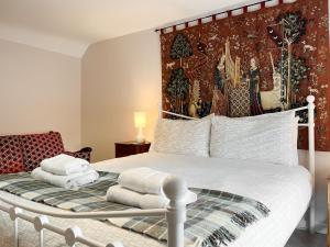 a bedroom with a white bed with towels on it at Bonsall View Cottage in Bonsall