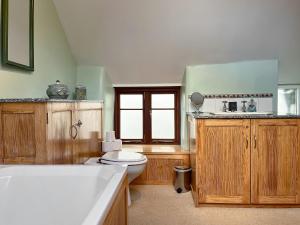 a bathroom with a toilet and a bath tub at Bonsall View Cottage in Bonsall