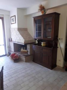 a living room with a fireplace and a wooden cabinet at RESIDENCE EDELWEISS in Spogna +5 photos