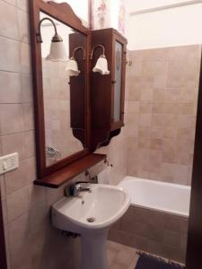 W łazience znajduje się umywalka, lustro i wanna. w obiekcie RESIDENCE EDELWEISS w mieście Spogna