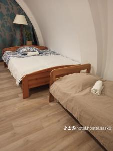 a bedroom with two beds and a lamp in it at Hotel-hostel Saska in Warsaw