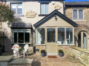 a house with a door and a table and chairs at Elizabeth Cottage in Glossop