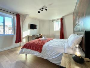 - une chambre avec un grand lit et une couverture rouge dans l'établissement Légendes de la piste - SOnights, à Château-du-Loir