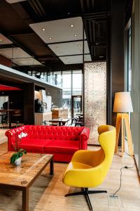 a living room with a red couch and a yellow chair at NEW OPENING 2022 - Los Lorentes Apartments Bern City in Bern