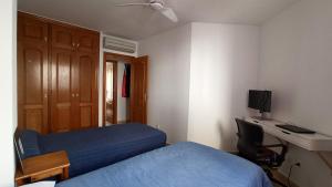 Schlafzimmer mit einem Bett, einem Schreibtisch und einem TV in der Unterkunft Apartamento en Portmán in Portman
