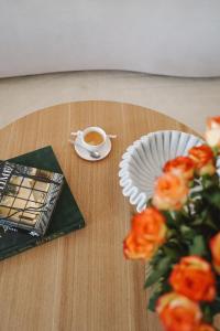 a table with a cup of coffee and a plate of roses at LOEWENHERZ HOMES Luxury Apartment - Stadt- und Seenähe - fellnasenfreundlich - lichtdurchflutet in Stephanskirchen