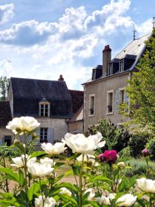 een huis met een tuin met bloemen ervoor bij Chambre d'hôtes "Au bord de Loire" in La Marche