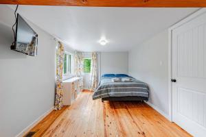 1 dormitorio con 1 cama en la esquina de una habitación en Pet Friendly Creekside Cabin At Darlington en Ligonier