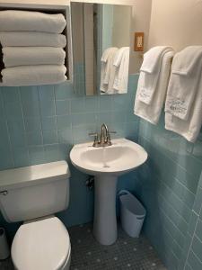 a bathroom with a sink and a toilet and towels at Large, Bright Suite Kitchenette in Ligonier