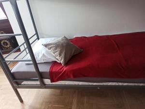 a metal bunk bed with a red blanket on it at Hotel-hostel Saska in Warsaw