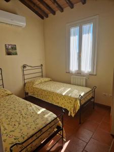 een slaapkamer met 2 bedden en een raam bij Agriturismo Piccolo Paradiso in Riparbella