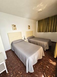 a room with two beds and a window at Apartamentos Don Vicente in Benidorm