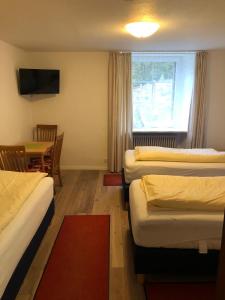 um quarto de hotel com três camas e uma mesa e uma janela em Gasthaus Hotel Löffelschmiede em Hinterzarten