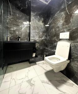 a black and white bathroom with a toilet and a sink at Guest House Gayane in Gyumri