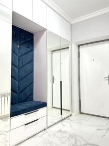 vestidor con banco azul y espejos en Guest House Gayane, en Gyumri