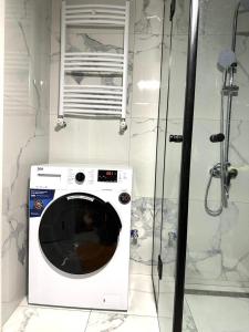 a washing machine in a bathroom with a shower at Guest House Gayane in Gyumri