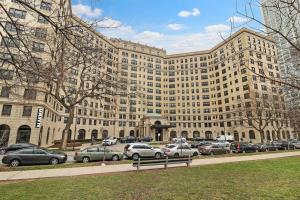 un gran edificio con coches estacionados en un estacionamiento en Calm & Cozy 1BR Furnished Apartment in Hyde Park - Windermere 402, en Chicago