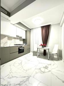 a kitchen with white marble flooring and a table at Guest House Gayane in Gyumri