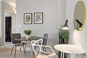 comedor con mesa, sillas y espejo en Calm & Cozy 1BR Furnished Apartment in Hyde Park - Windermere 402, en Chicago
