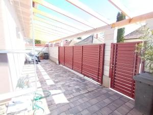 a patio with red gates on a house at Flower 3 free parking in Siófok