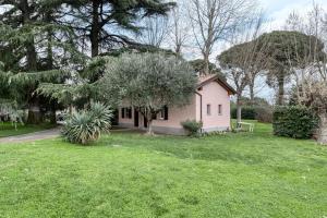 mały różowy dom na podwórku z drzewami w obiekcie Villa Govi-Pancaldi w mieście San Lazzaro di Savena