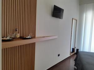Habitación con estantería y TV en la pared en Borgo Fontana B&B en Bari