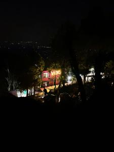 una casa iluminada por la noche con luces en Vibe Hostel en Dharamshala