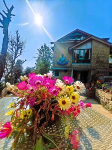 een boeket bloemen voor een huis bij Vibe Hostel in Dharamshala