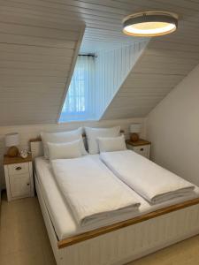 1 cama con sábanas blancas y almohadas en una habitación en Bella Mura Nature Apartment Lipa 97 en Podčetrtek