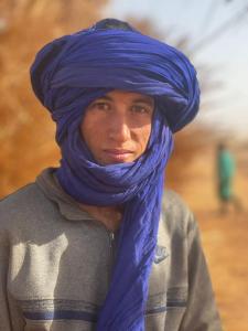 mężczyzna w niebieskim szaliku wokół głowy w obiekcie Adventure dans le desert w mieście Tagounite