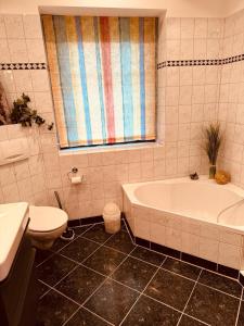 een badkamer met een bad, een toilet en een wastafel bij Ferienwohnung Marienau in Coppenbrügge
