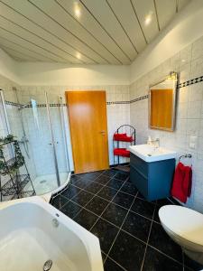 a bathroom with a tub and a toilet and a sink at Ferienwohnung Marienau in Coppenbrügge
