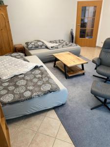 a room with two beds and a table and a chair at Ferienwohnung Marienau in Coppenbrügge