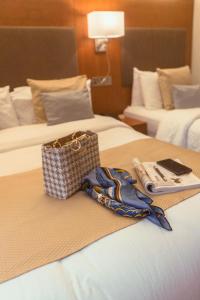 un bolso y una toalla en una cama en una habitación de hotel en Uppercross House Hotel, en Dublín