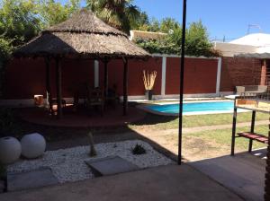 una piscina con sombrilla junto a una piscina en Dharma en Luján de Cuyo