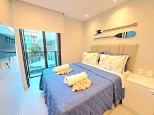 a bedroom with a bed with two pillows on it at Flat no Centro de Porto de Galinhas -SUNNY HALL120 in Porto De Galinhas +69 photos