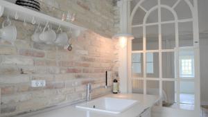 a kitchen with a sink and a brick wall at Store Ejlstrup Bed & Breakfast in Odense